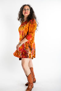 Susan wearing a orange long sleeve tie dye dress in the color Sunset