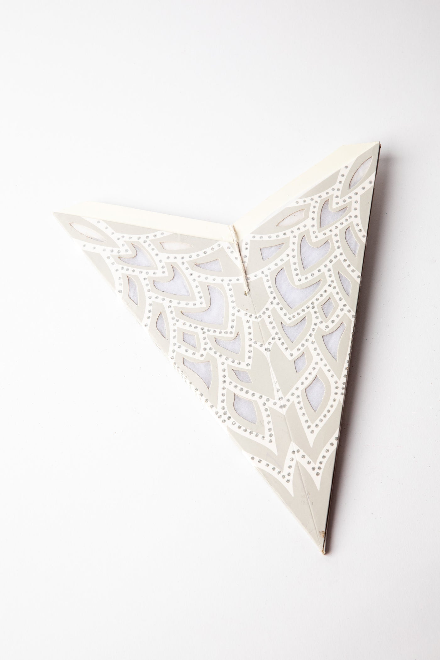 Silver embroidered paper star folded up, out of the package