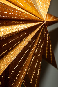 A detailed shot of a glittering gold star lantern