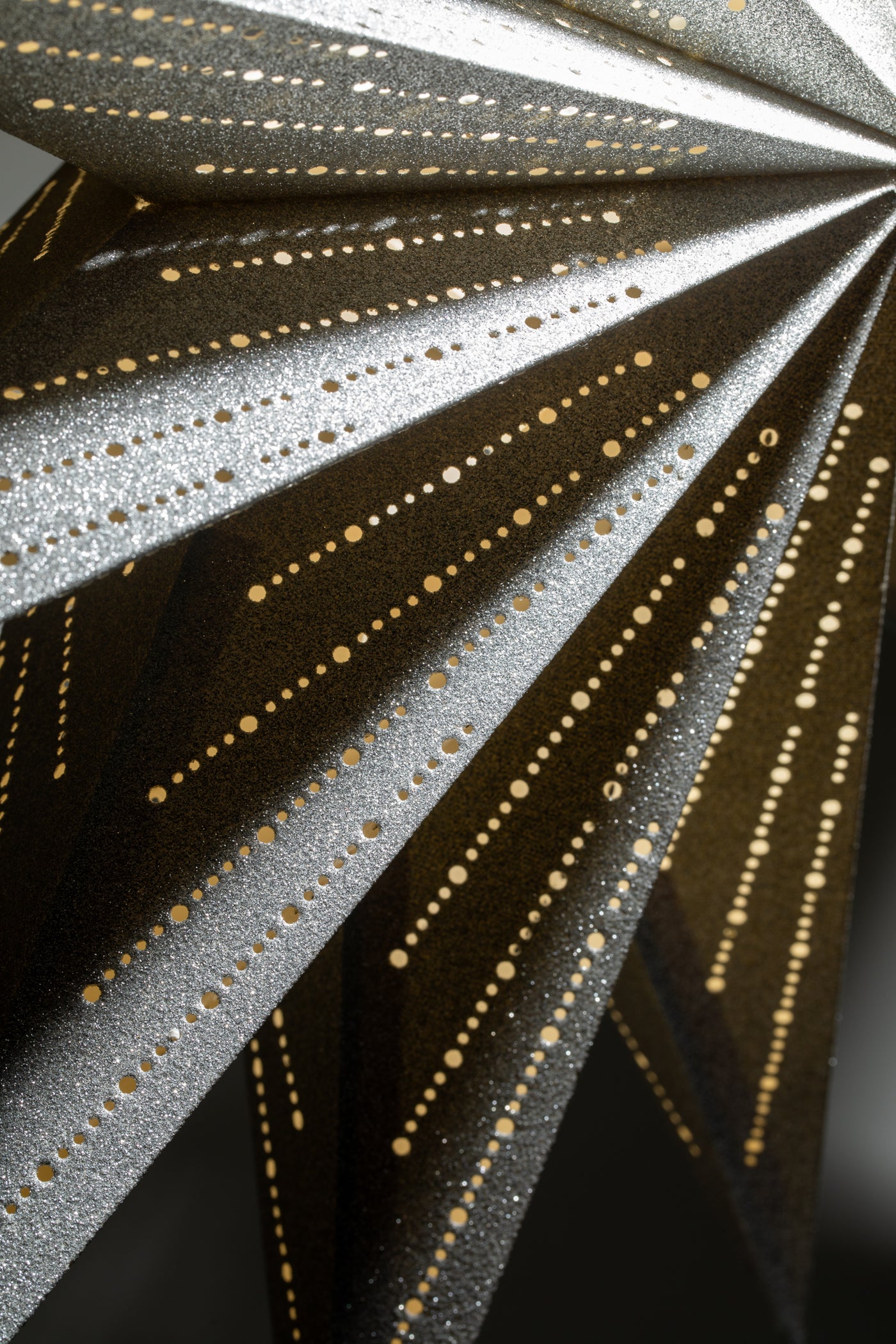 A close up of a silver glittering paper star lantern. 