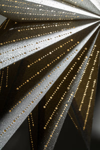 A close up of a silver glittering paper star lantern. 