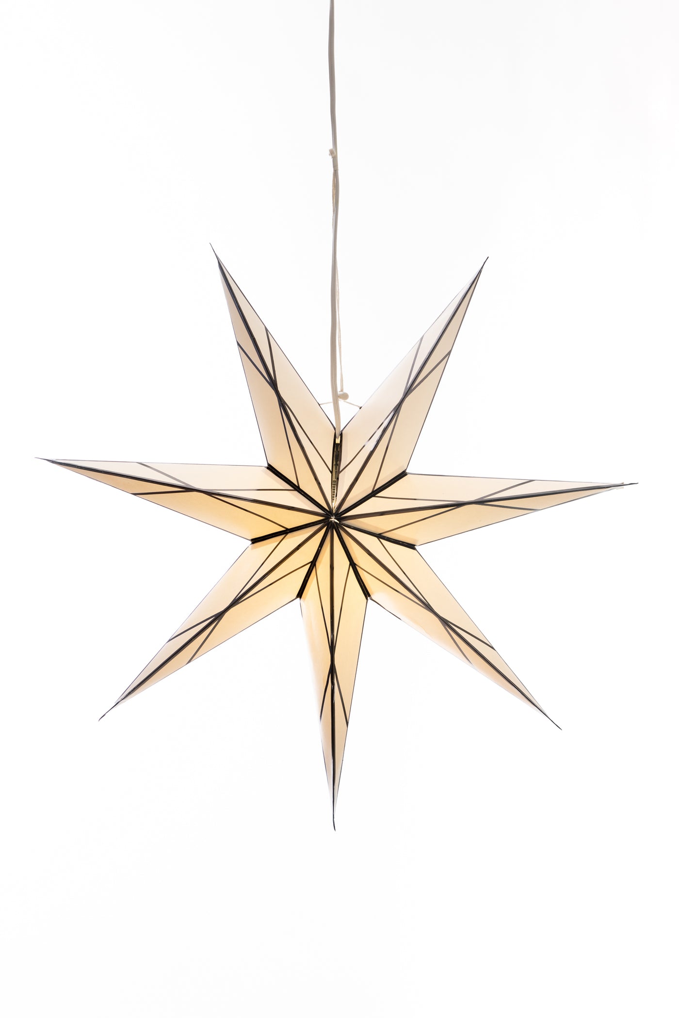 A hanging 7-point paper star lantern in a white and black glass effect hanging in front of a white background. 