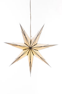 A hanging 7-point paper star lantern in a white and black glass effect hanging in front of a white background. 
