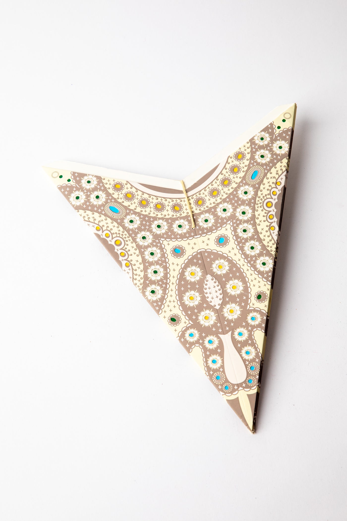 Creme embroidered paper star folded up, out of the package