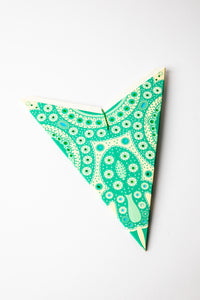 Green embroidered paper star folded up, out of the package