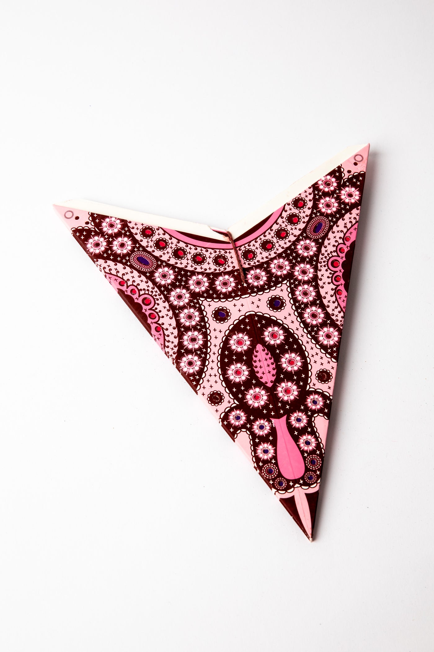 Pink embroidered paper star folded up, out of the package