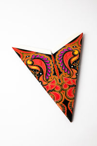 Red and Gold embroidered paper star folded up, out of the package