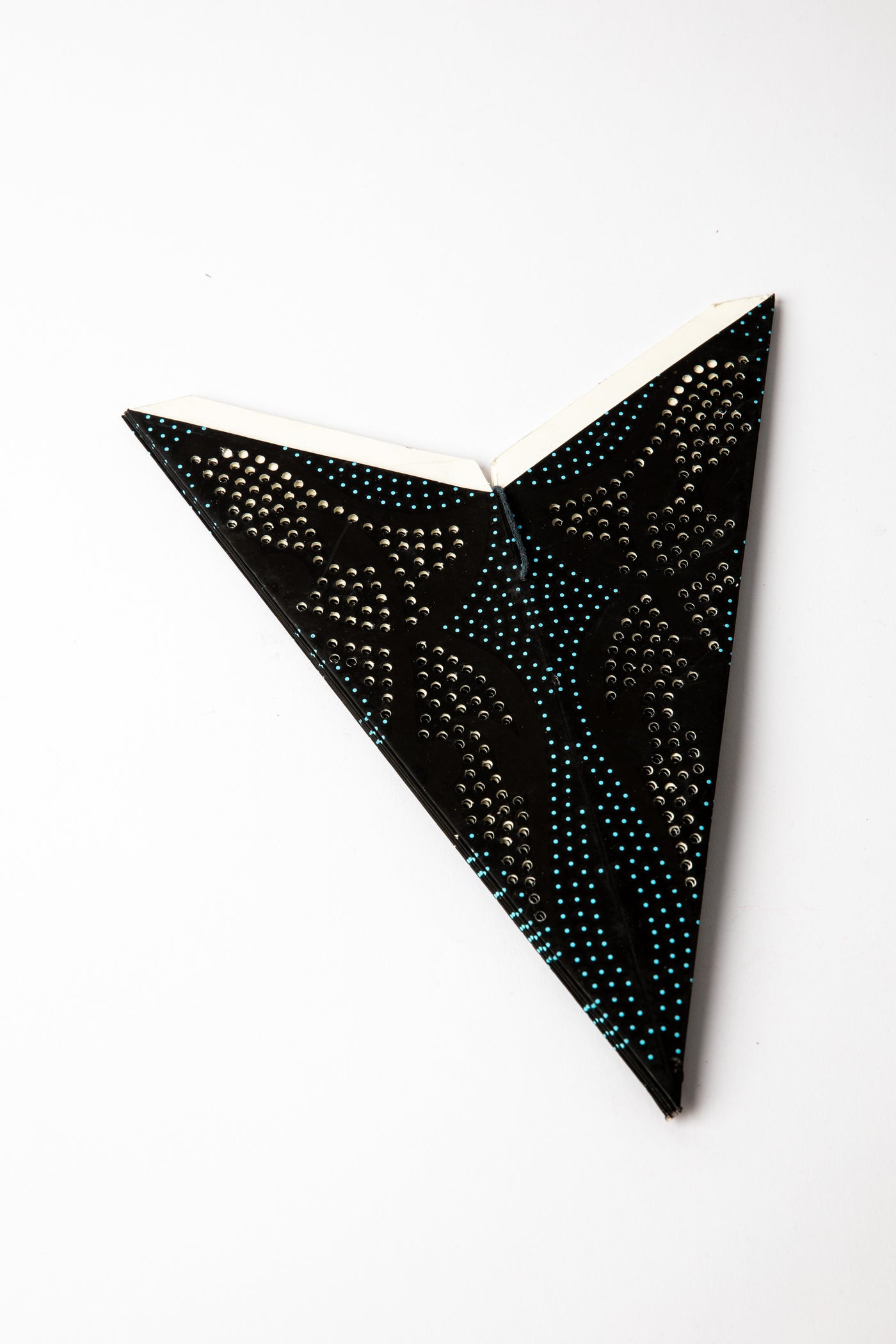 Blue and Black dotted embroidered paper star folded up, out of the package