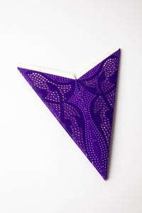 Purple dotted embroidered paper star folded up, out of the package