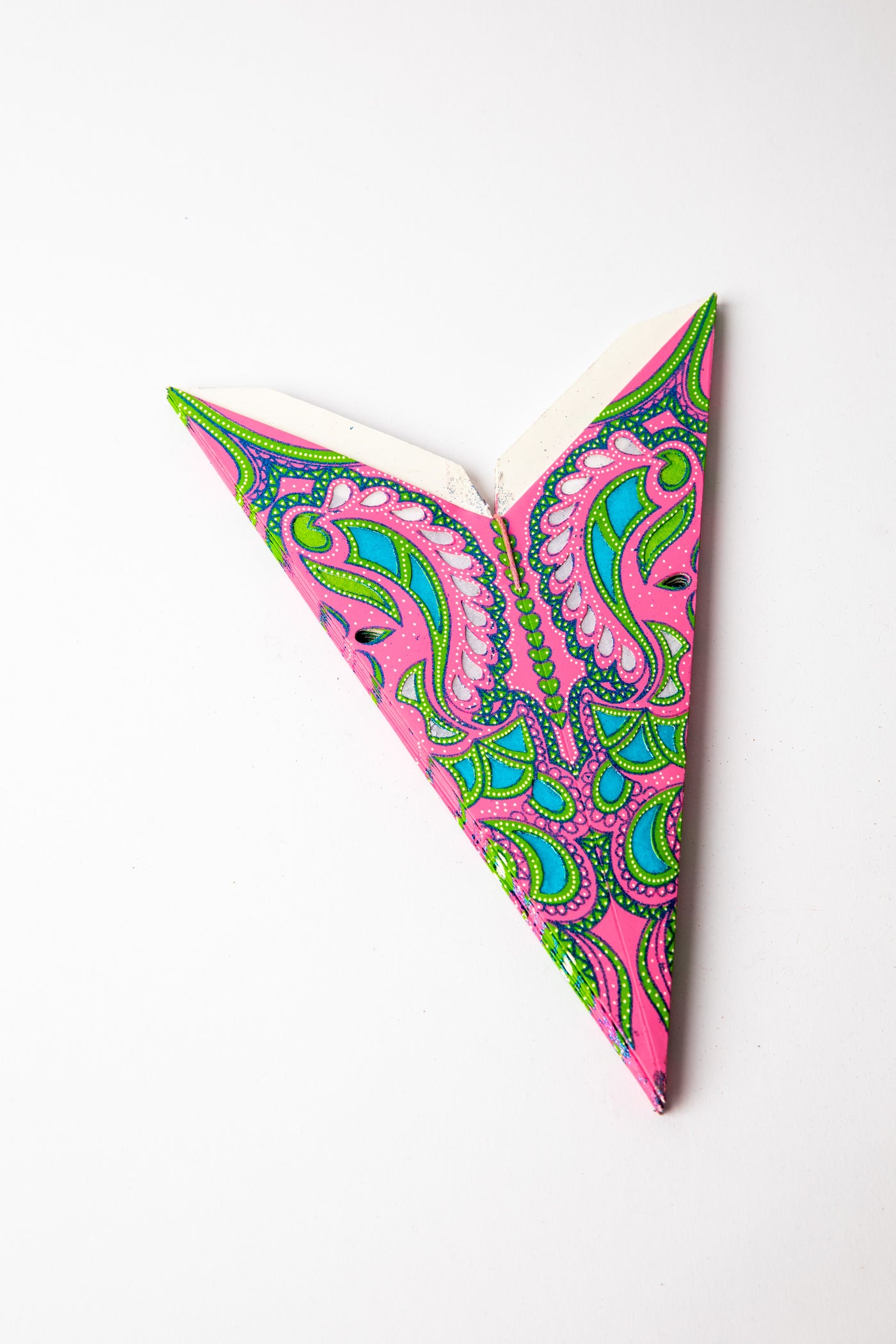 Pink and Green embroidered paper star folded up, out of the package