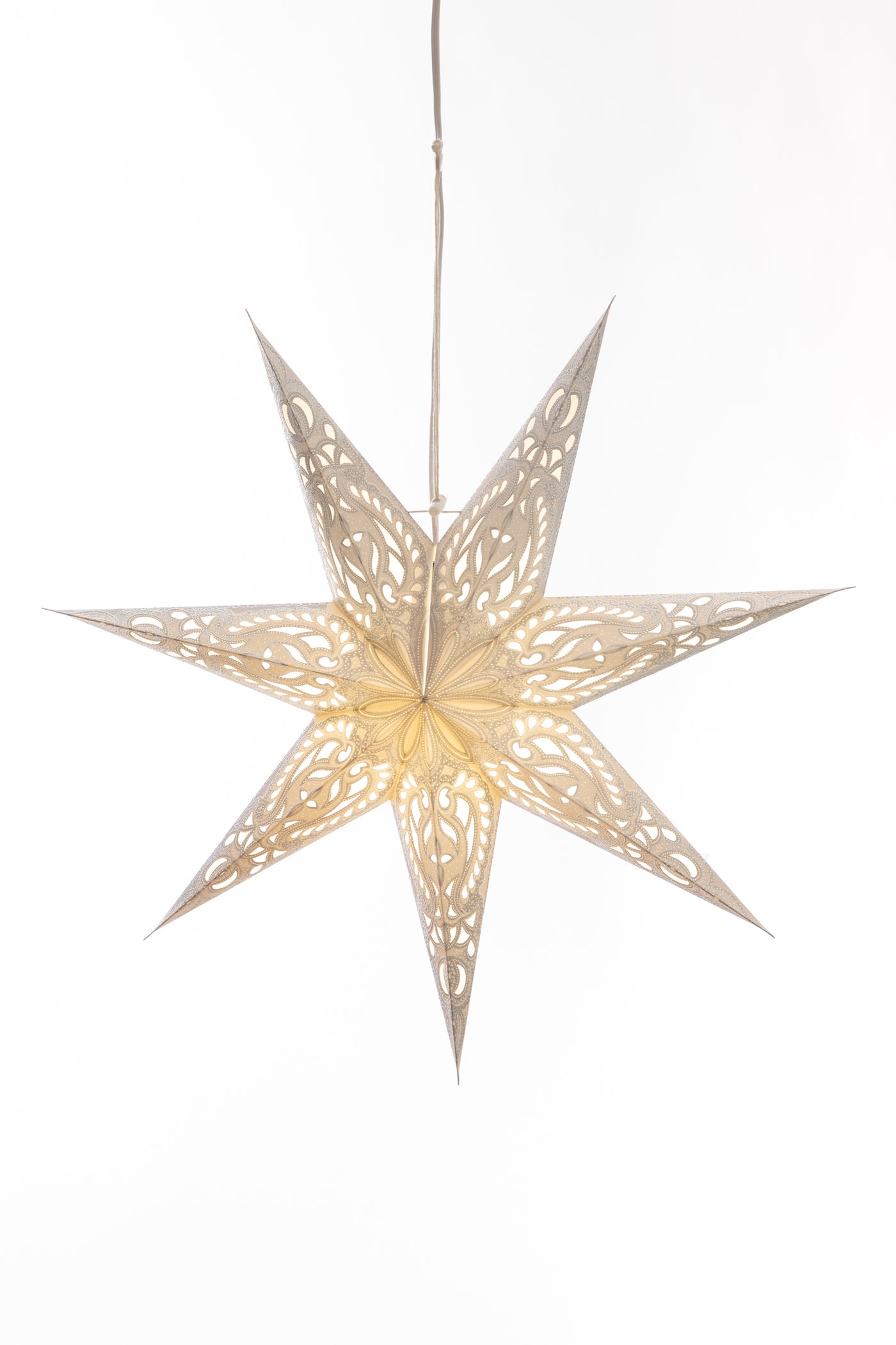 A white 7-point star lantern with an intricate design in front of a white backdrop. 