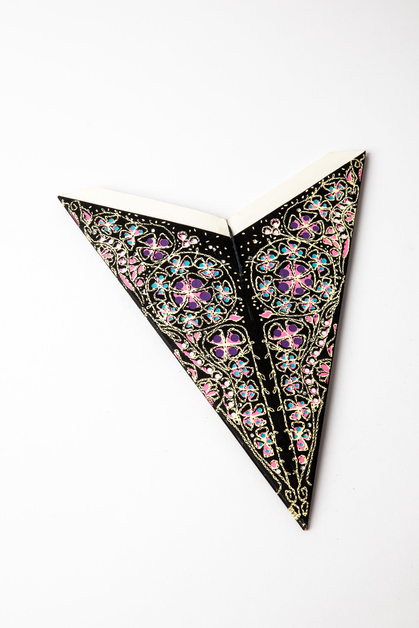 Pink and Black embroidered paper star folded up, out of the package