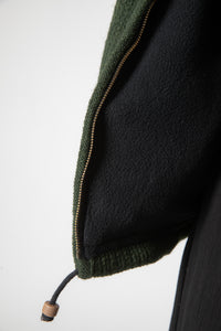 Detail of drawstring and zipper on dark green wool hooded jacket