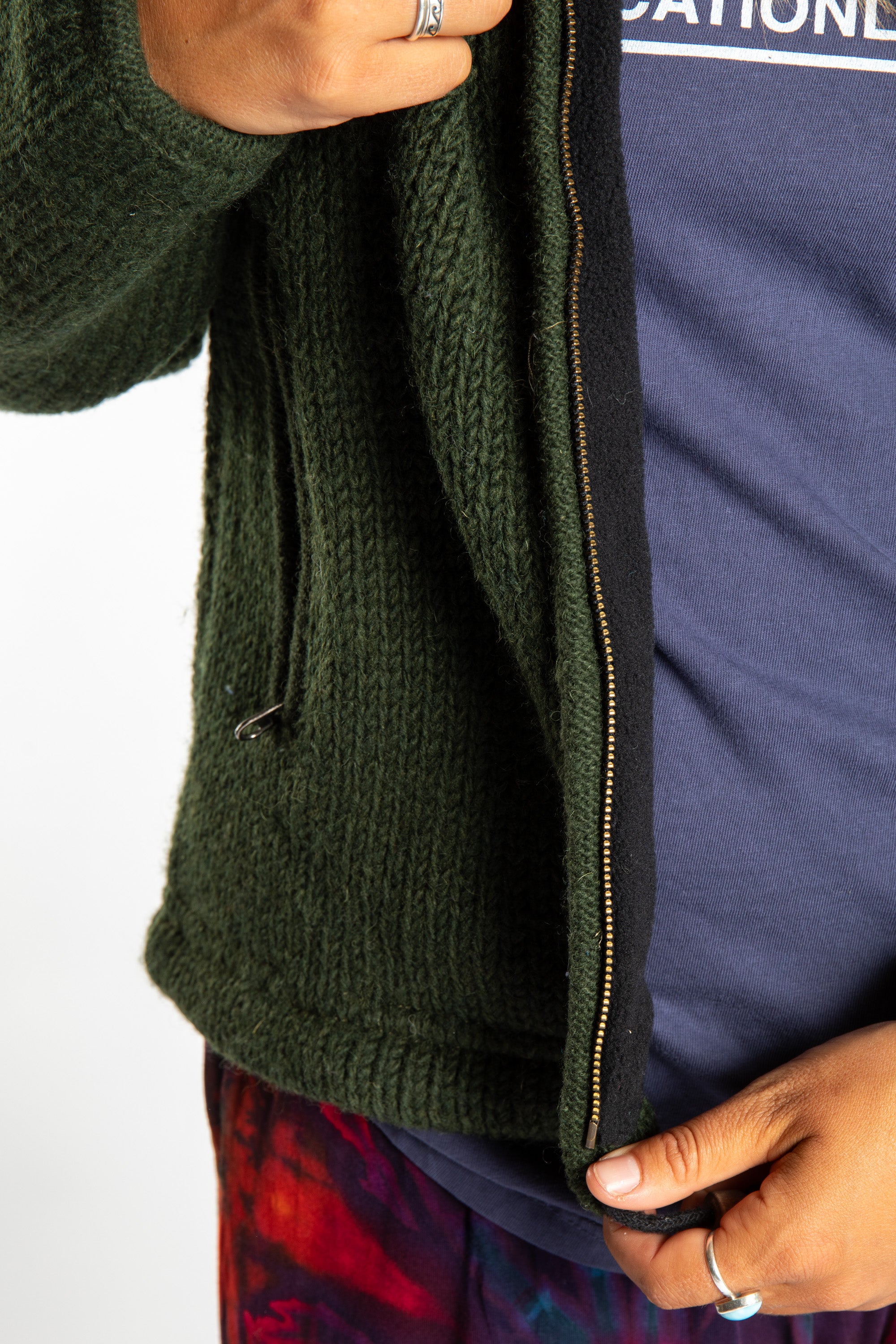detail of zipper on dark green wool hooded jacket