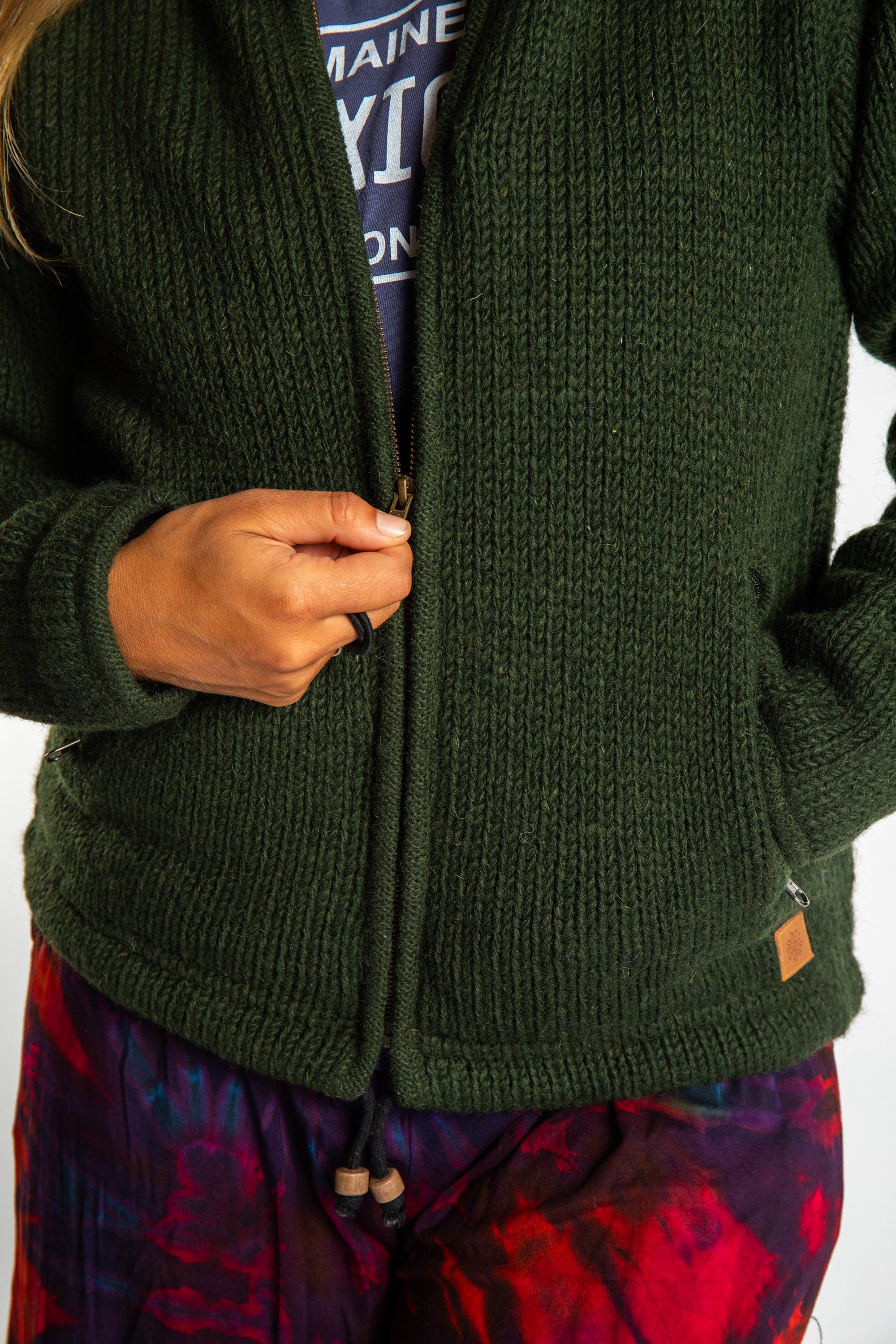 detail of zipper on dark green wool hooded jacket