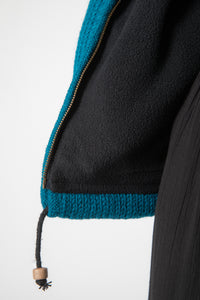 Detail of drawstring and zipper on teal wool hoodie jacket