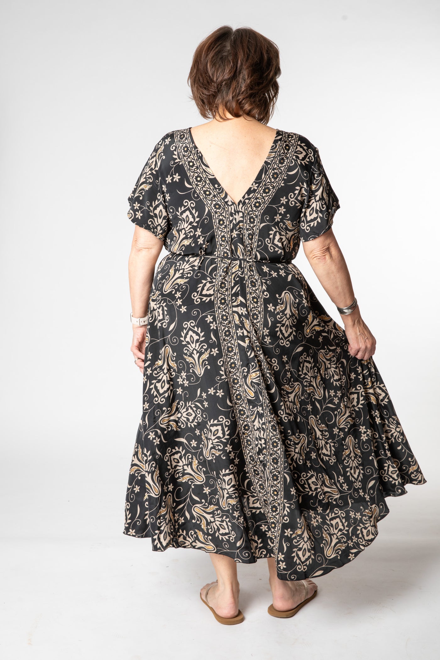 Betty is wearing a flowy dress in black vines