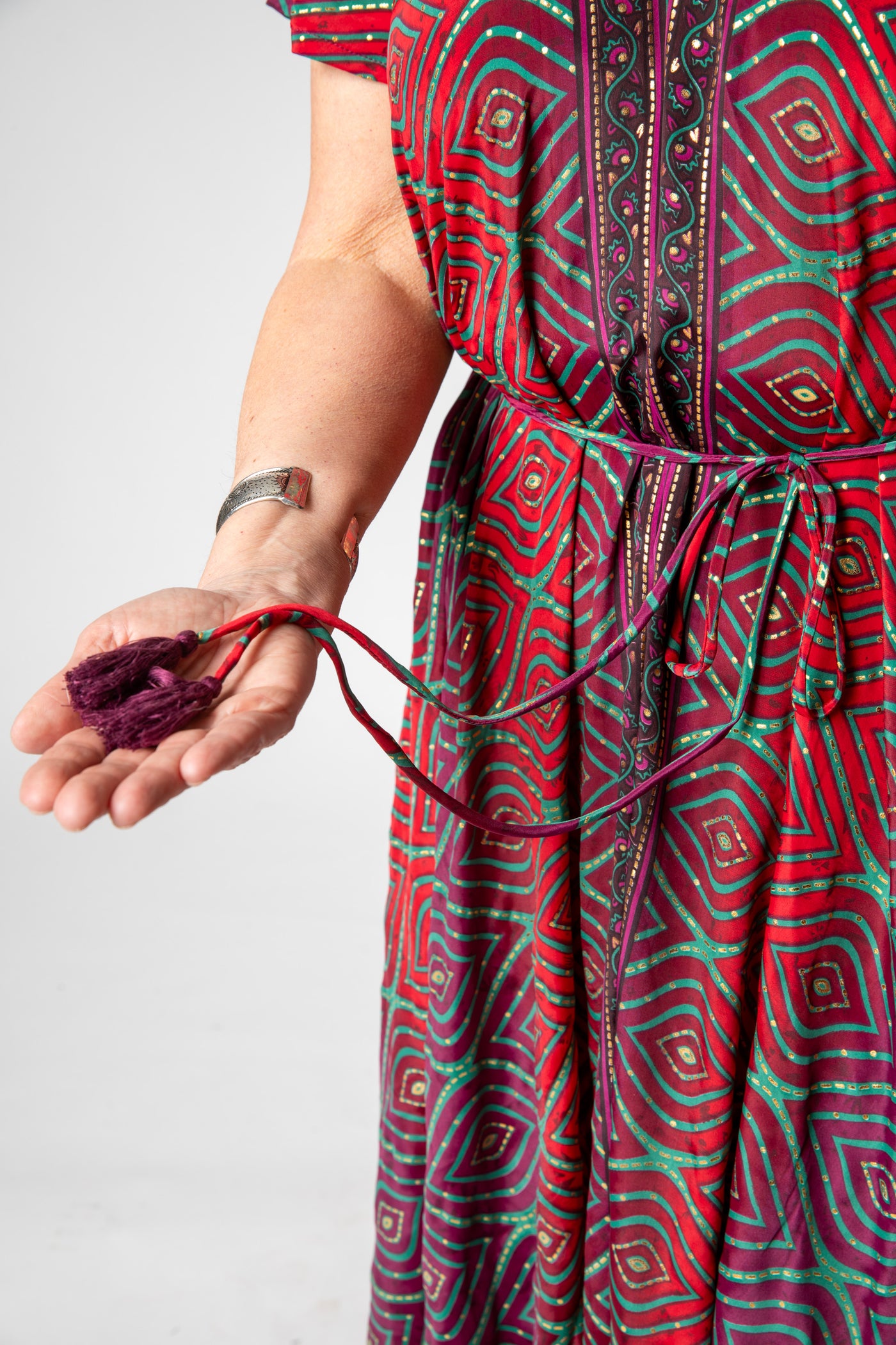 Betty is wearing a flowy dress in burgundy bulbs