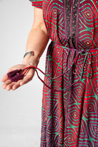 Betty is wearing a flowy dress in burgundy bulbs