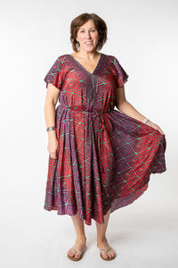 Betty is wearing a flowy dress in burgundy bulbs