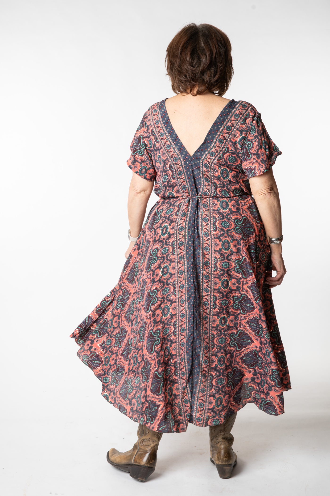 Betty is wearing a flowy dress in coral canopy
