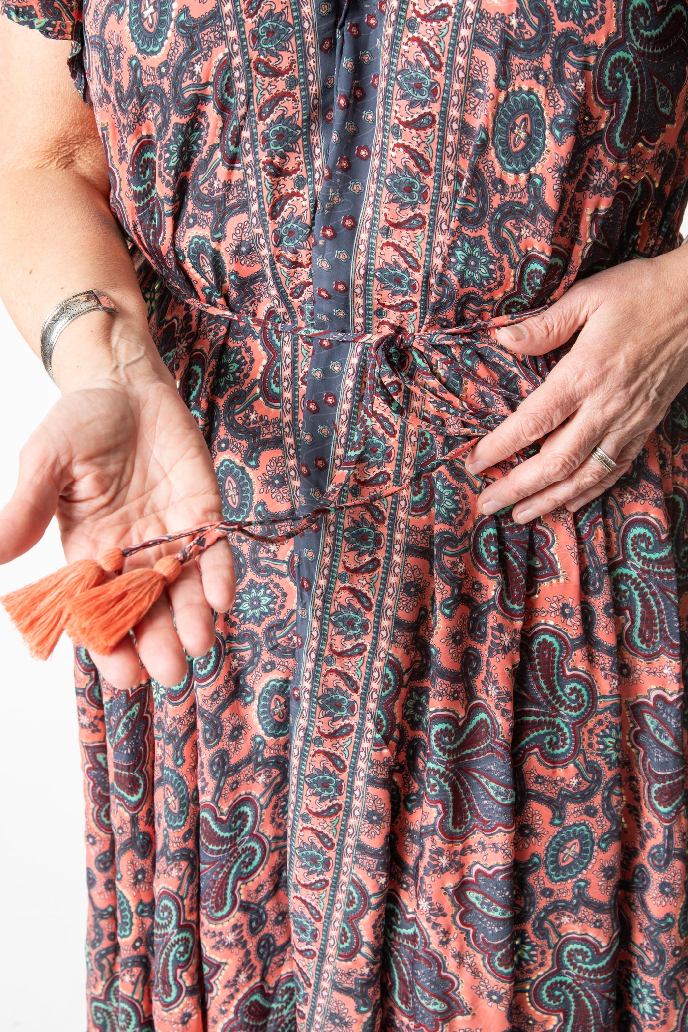 Betty is wearing a flowy dress in coral canopy