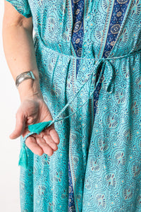 Betty is wearing a flowy dress in sky blue palms
