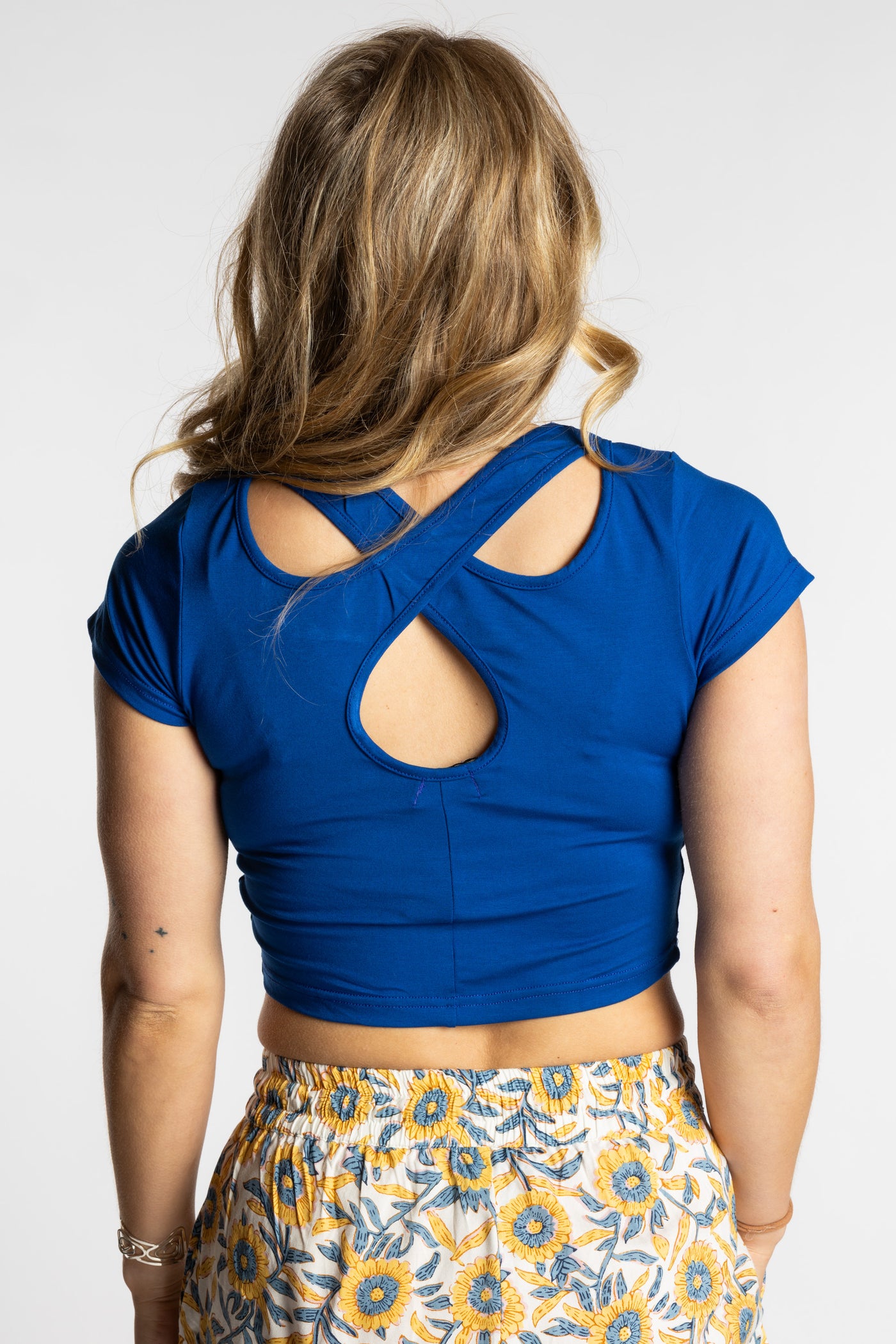 Sophie is wearing the S/M blue Cobalt cross back crop top