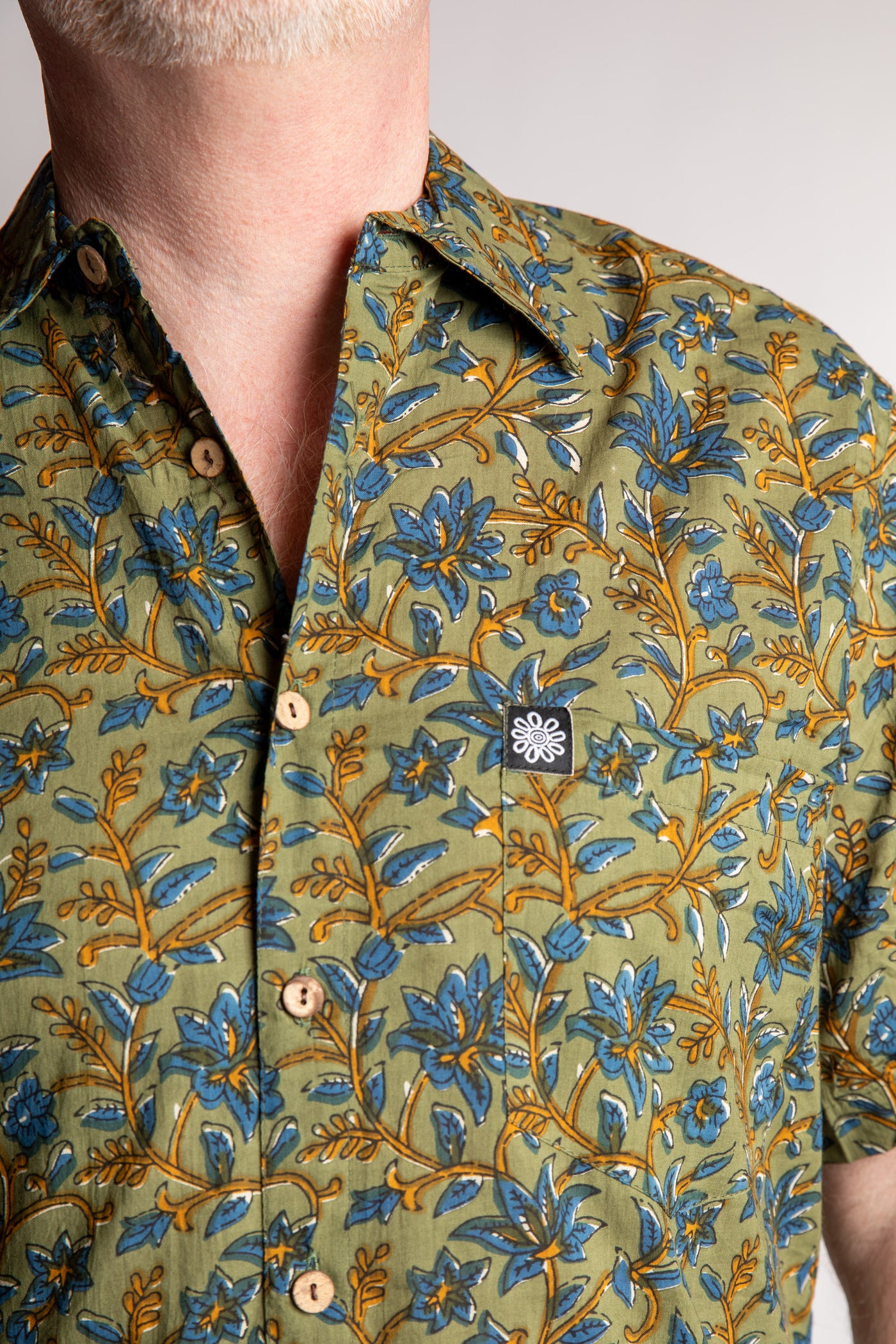 Chris, 5'7", wearing the LaLa Printed Cotton Button Up in Sage Floral, size M