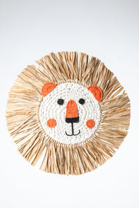 Macrame wall hanging in the shape of a lion's face with a mane made from palm fronds.