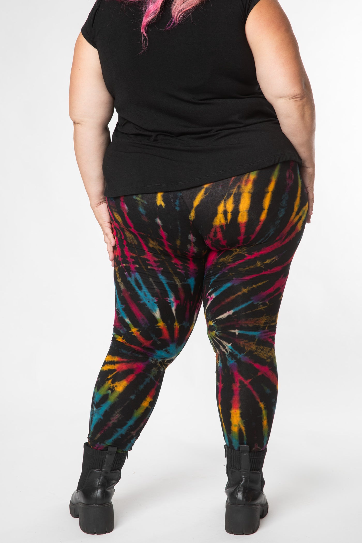 Hippie woman facing backwards wearing cozy tie dye leggings with a black rainbow tie dye pattern