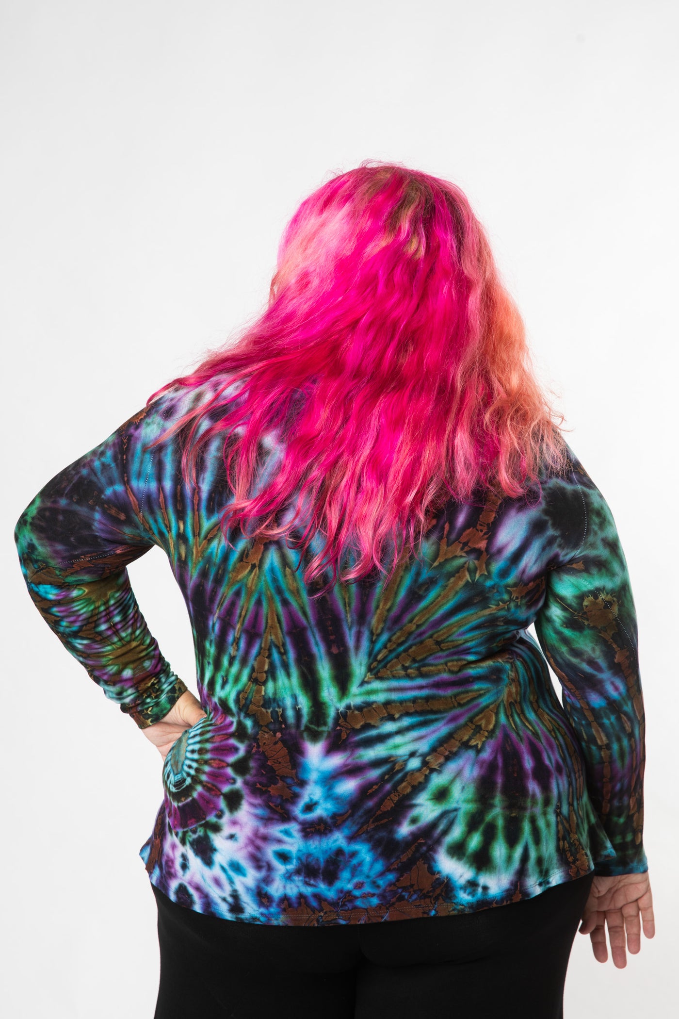 Angel is wearing long sleeve tie dye top in ocean