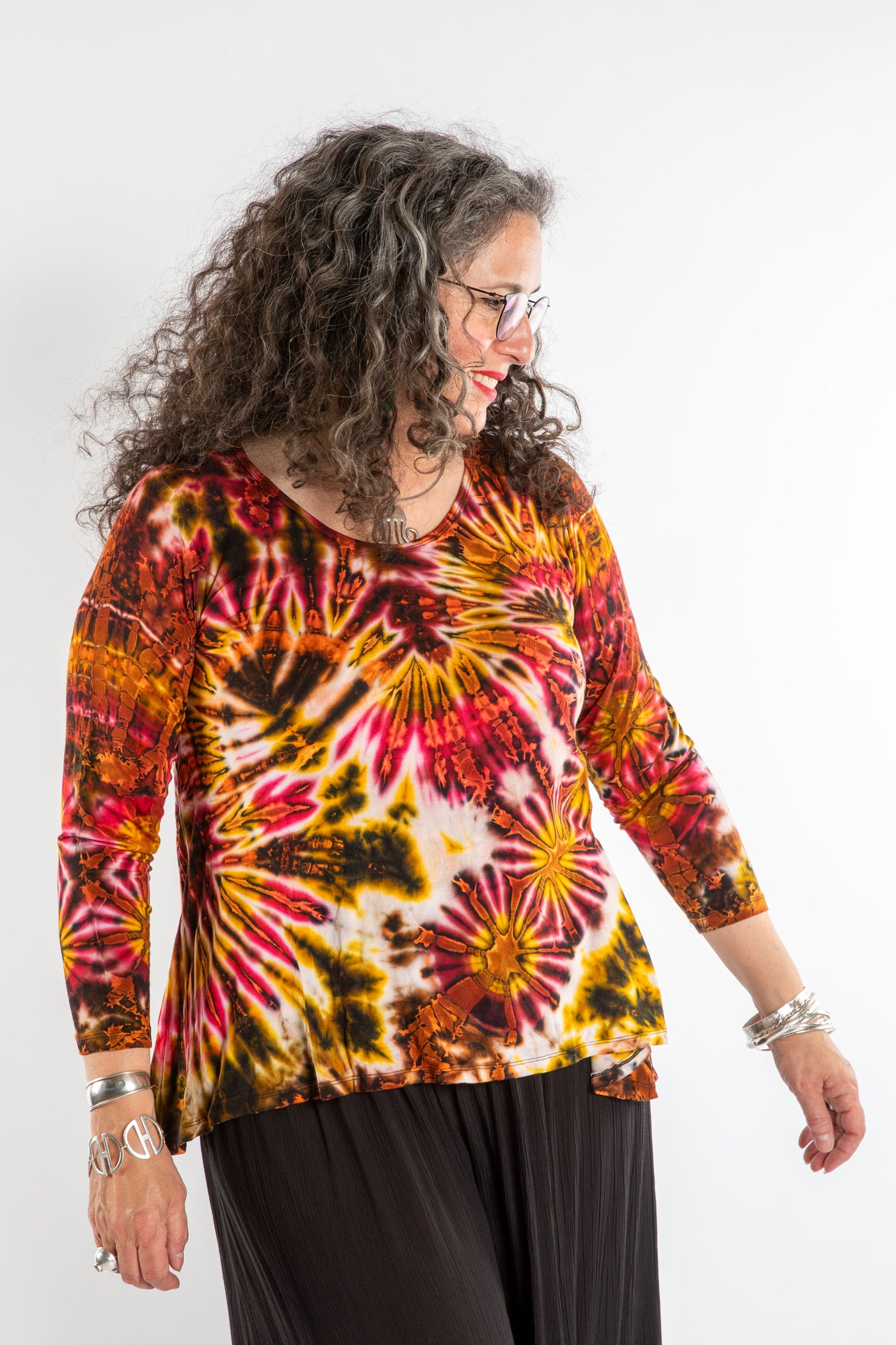 Susan wearing a orange long sleeve tie dye shirt in Sunset