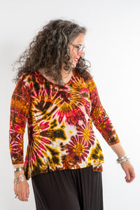 Susan wearing a orange long sleeve tie dye shirt in Sunset