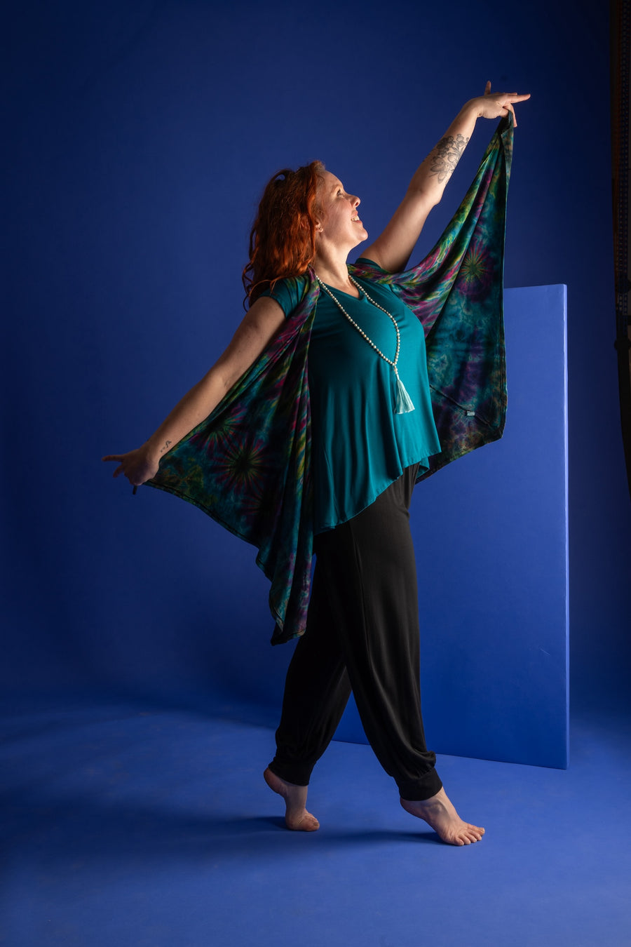 Maggie is wearing a wrap vest in teal