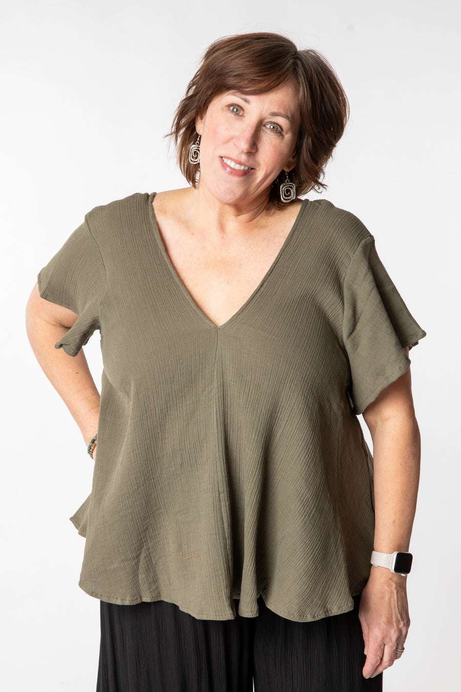 Betty is wearing a cotton top in sage
