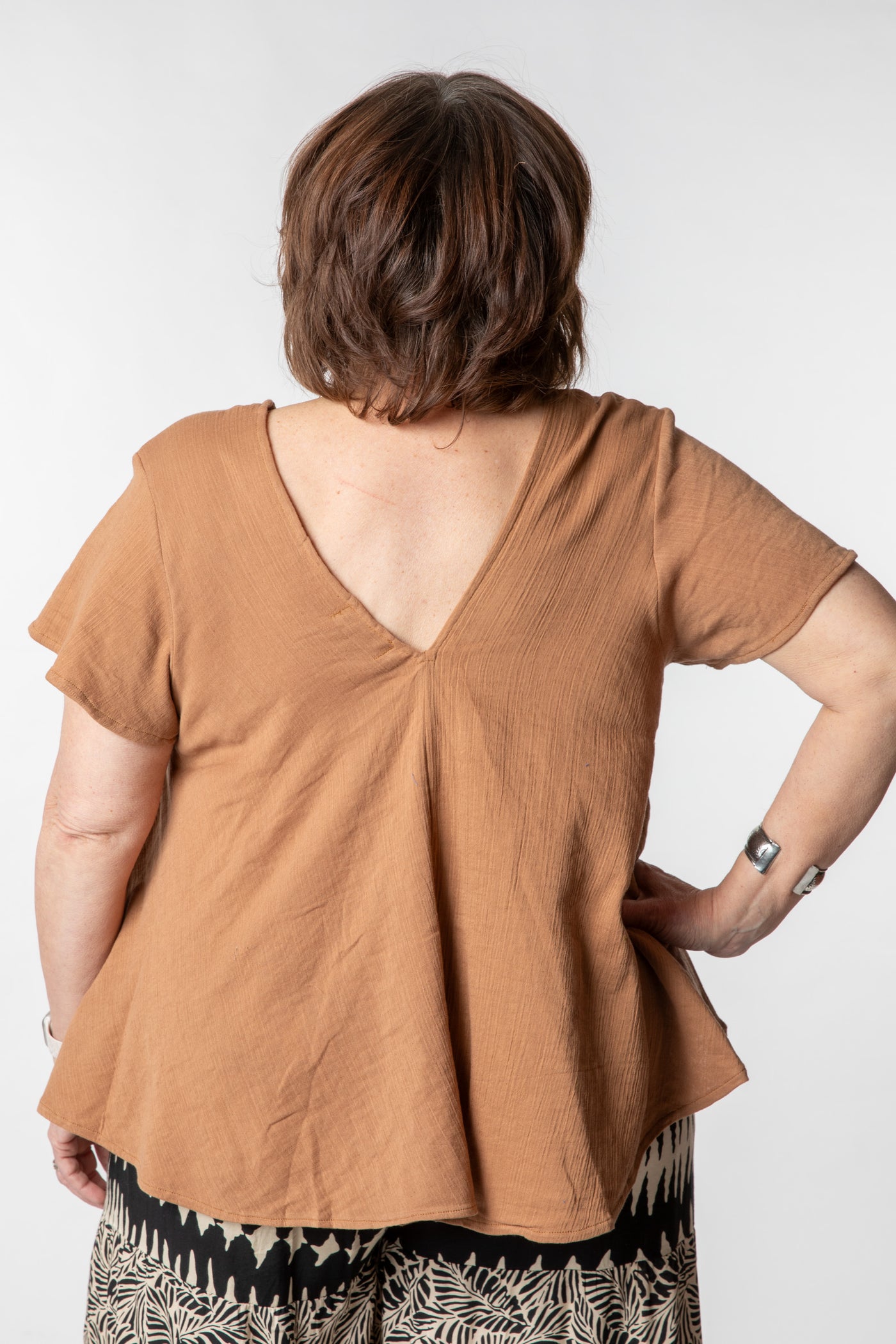 Betty is wearing a cotton top in tan