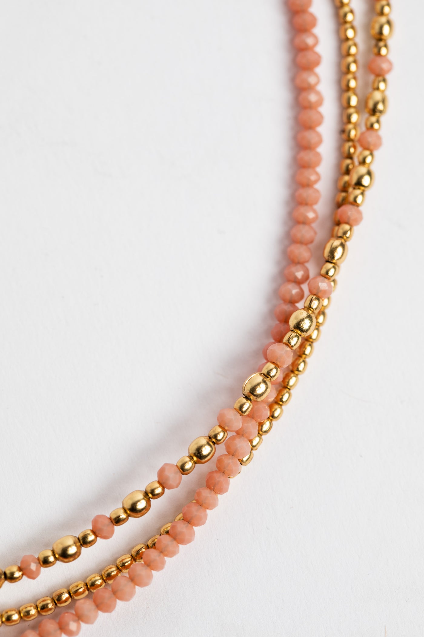 layered beaded necklace in pink on white background