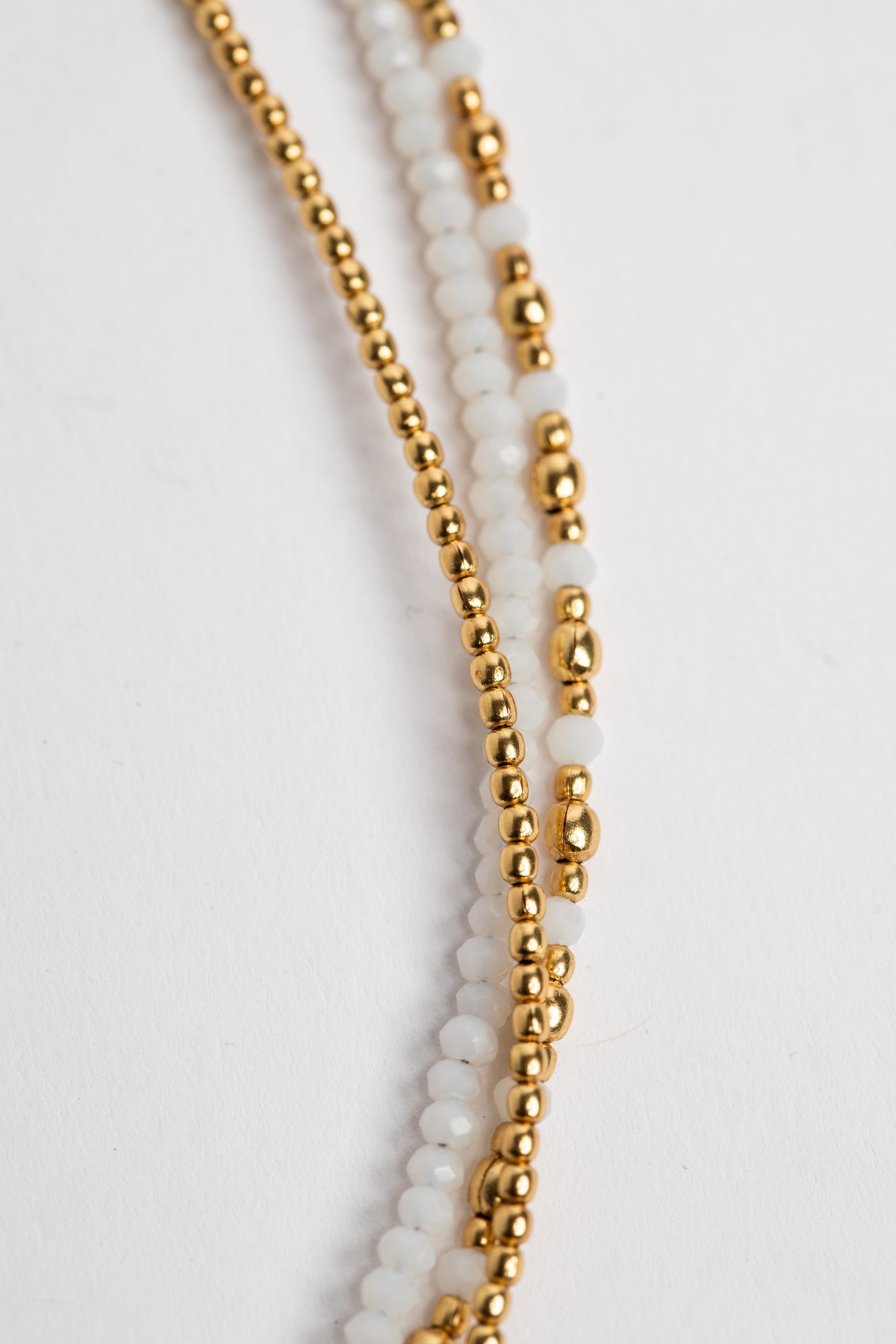 layered beaded necklace in white on white background