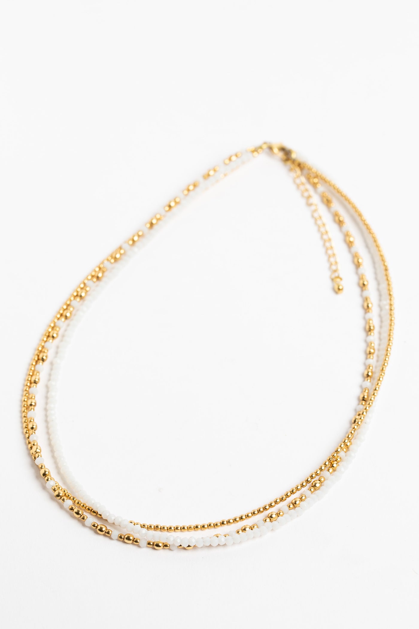 layered beaded necklace in white on white background