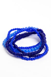 stackable beaded bracelets in blue on white background