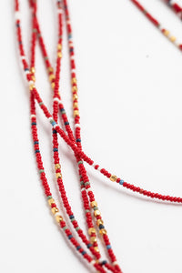 multi strand beaded necklace in red on white background
