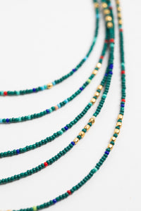 multi strand beaded necklace in teal on white background