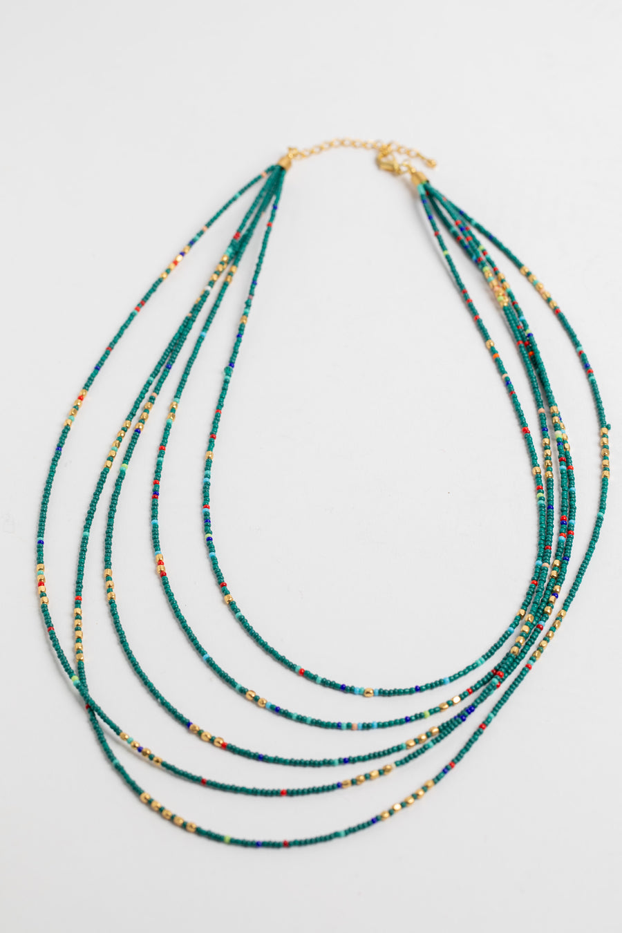 multi strand beaded necklace in teal on white background