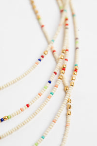 multi strand beaded necklace in white on white background