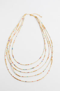 multi strand beaded necklace in white on white background