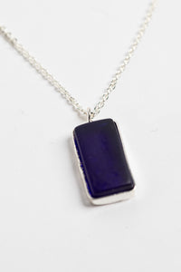 minimalist boho necklace pendant in blue on white background
