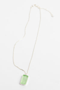 minimalist boho necklace pendant in green on white background