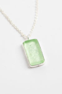 minimalist boho necklace pendant in green on white background