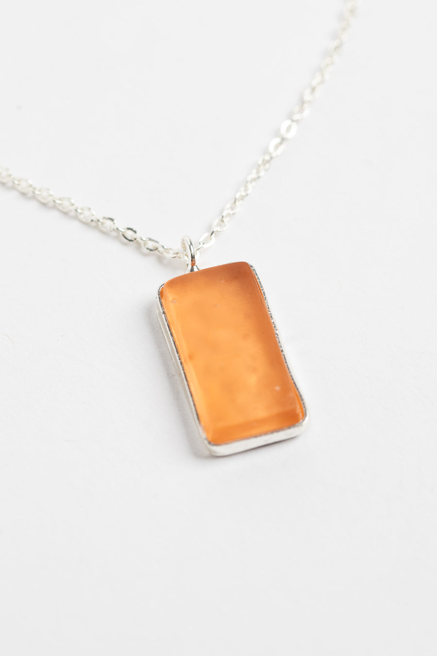 minimalist boho necklace pendant in pink on white background